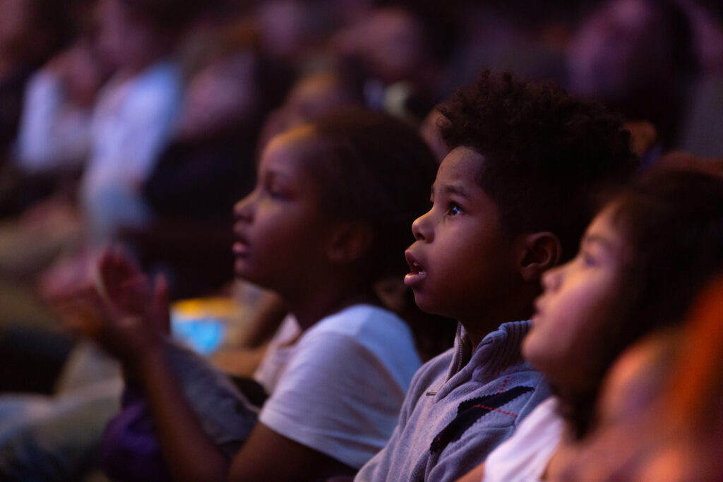 A young boy looking up at a New Victory performance.