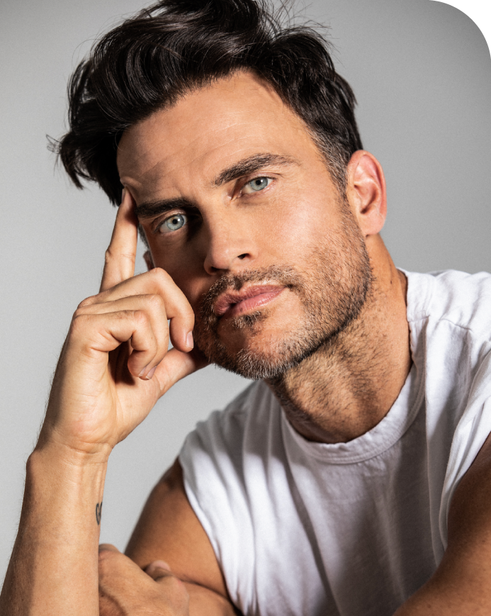 Headshot of Cheyenne Jackson with his head resting on his hand